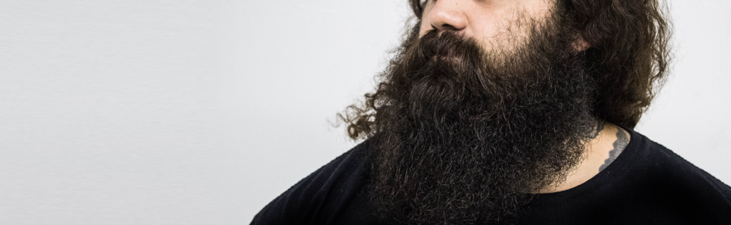Homem com barba muito grande e bem cuidada com produtos de qualidade